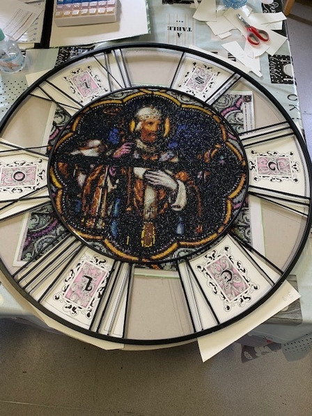 Photo d’une création originale dans le cadran d’une horloge regroupant les techniques du vitrail et de l'enluminure.